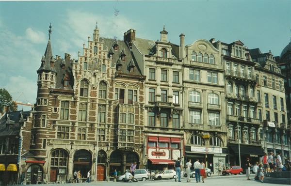 Ornate brick and stone guildhalls on Antwerp's Grote Markt, pedestrians and cars