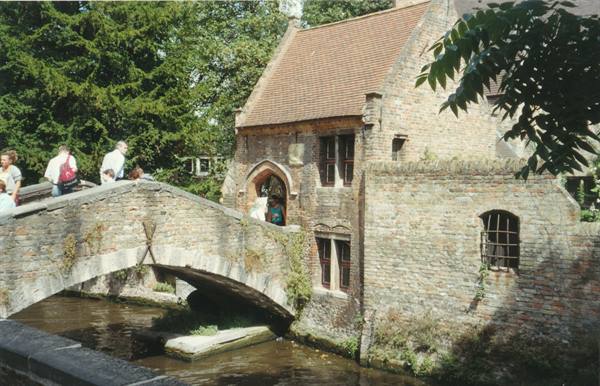 Stone bridge over the canal in front of medieval brick houses in Bruges