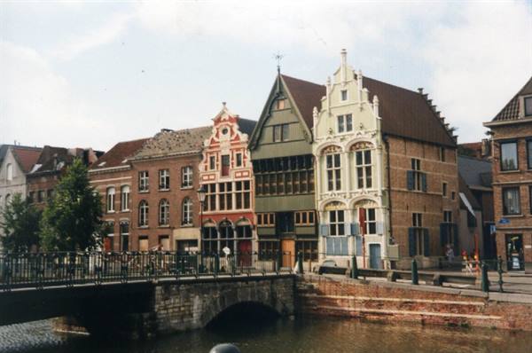 Historic guild houses along Ghent canal, stone bridge, soft daylight