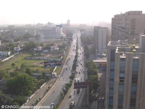 Busy avenue between buildings and haze, Karachi