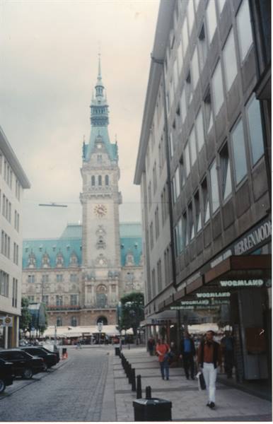 Pedestrians on a shopping street in front of Hamburg's city hall