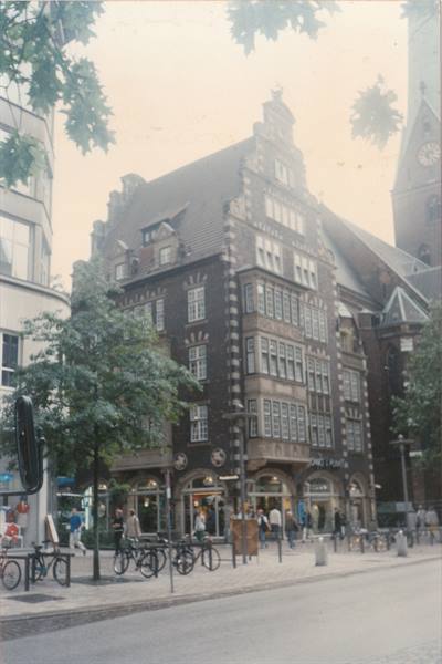 Brick building with stepped gable, bicycles parked along the street