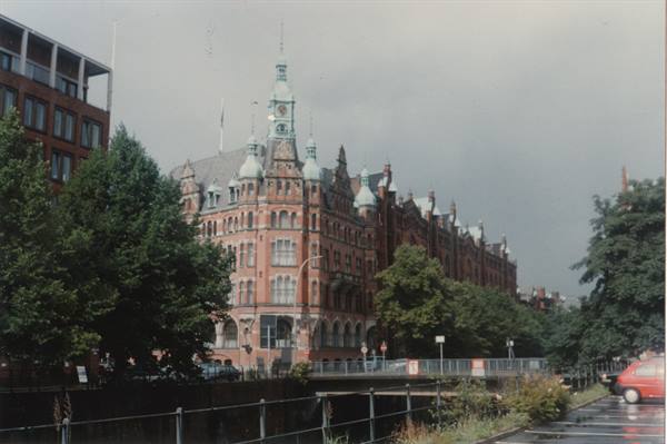 Red-brick building with green spires at Hamburg Speicherstadt, grey sky