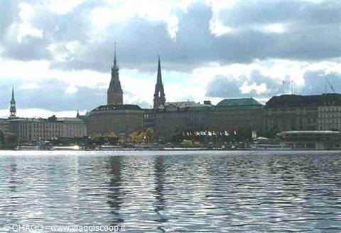 Hamburg spires and buildings reflected in the Alster lake under grey clouds
