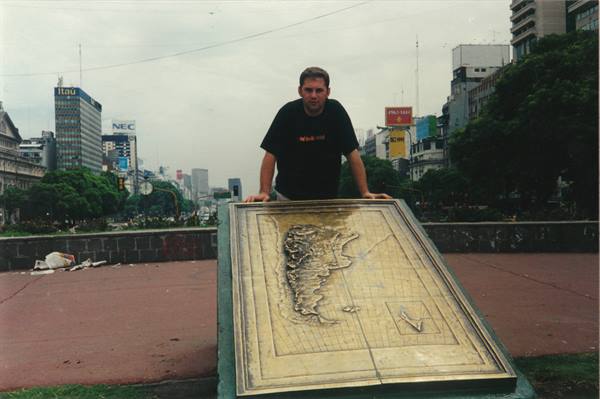 Young man leaning on bronze map of Argentina on Avenida 9 de Julio, Buenos Aires