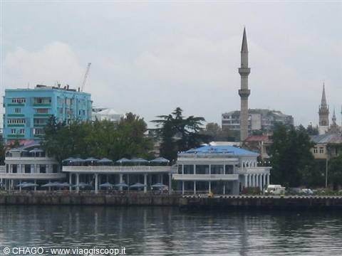Minaret and blue buildings along Batumi waterfront, grey light on the water