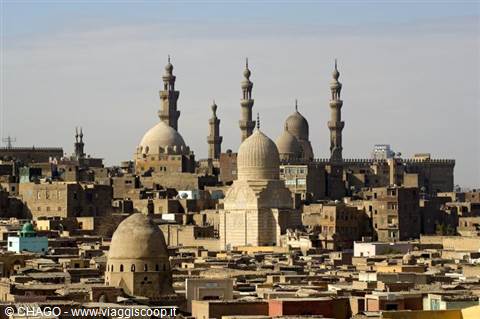 Stone minarets and domes of Islamic Cairo among low houses