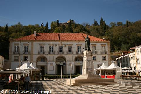 Stone statue and white building in Coimbra square