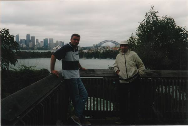 Two friends on a wooden walkway, Sydney Harbour Bridge in the background