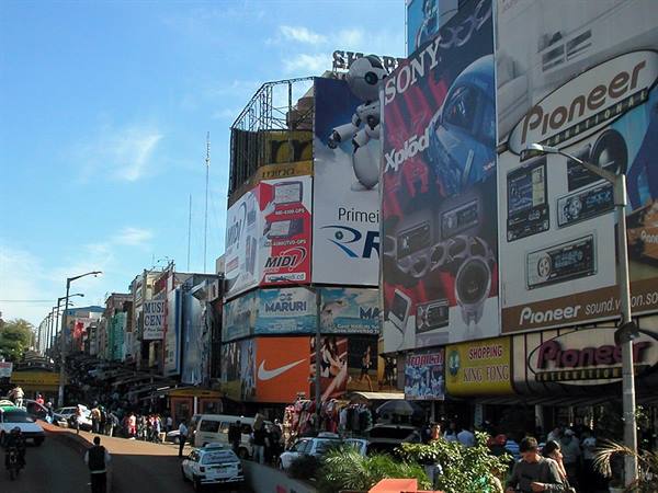 Busy street lined with giant Sony and Pioneer billboards, traffic and pedestrians