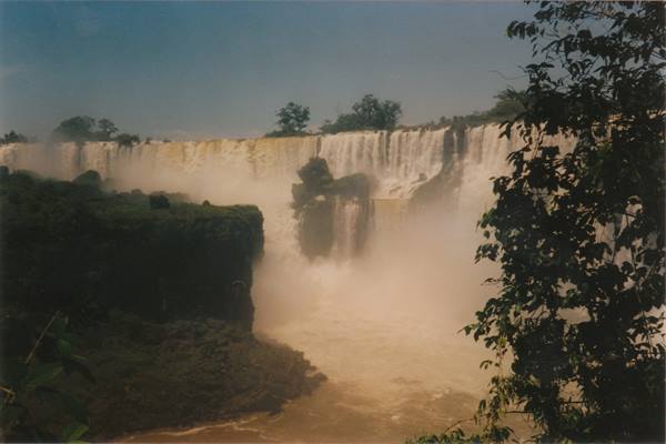 Iguazú Falls, white water plunging over rocks amid lush greenery