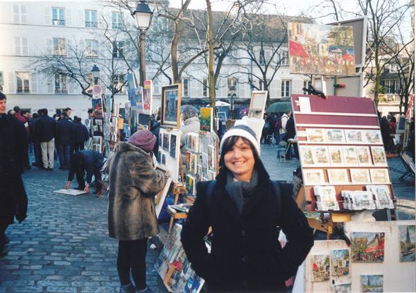 Smiling tourist among the painters of Place du Tertre, Montmartre, Paris