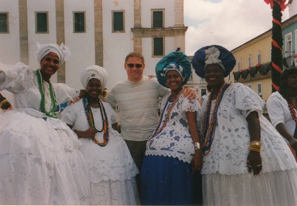 Tourist posing with four Baiana women in white dresses, Salvador