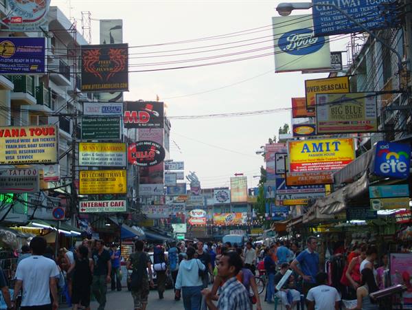 Crowd of tourists among bright signs for bars, tours and internet cafés on Khao San Road