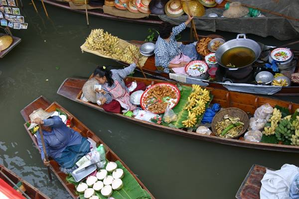 Damnoen Saduak floating market, women on wooden boats selling bananas and food
