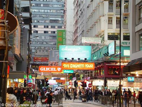 Bright shop signs above the crowd in a busy Hong Kong street