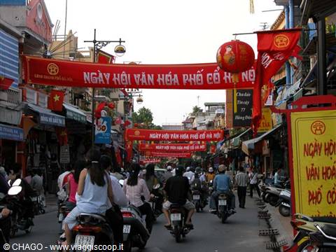 Scooter traffic under red banners for Hanoi Old Quarter festival