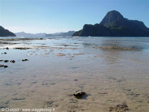 Low tide on sandy beach at El Nido, limestone mountain in background