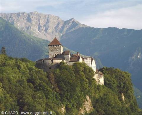 Gutenberg Castle with stone tower and red roof on forested hill among mountains