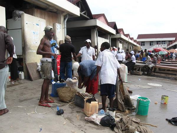 Men with baskets and buckets unloading fish at Saint Paul covered market