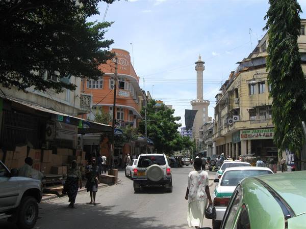 Busy street with cars, white minaret among colonial buildings in Mombasa