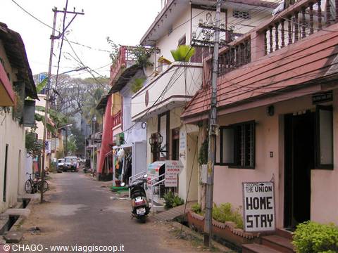 Alley with parked scooter and Home Stay sign on pink house