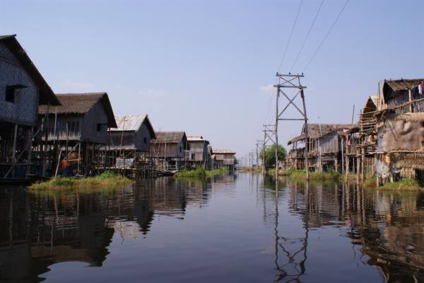 Wooden stilt houses lining a calm canal at Inle Lake