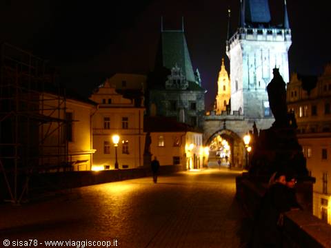 Statues and lit lamps at night on Charles Bridge, Prague