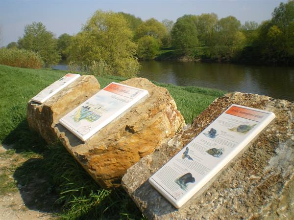Information panels on stone boulders beside a river