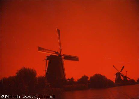 Dutch windmills silhouetted against an intense red sky
