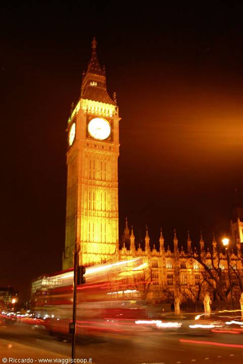 Illuminated Big Ben at night in London, light trails from passing buses
