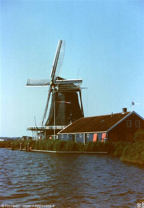 Wooden windmill with dark houses along the canal, Zaanse Schans