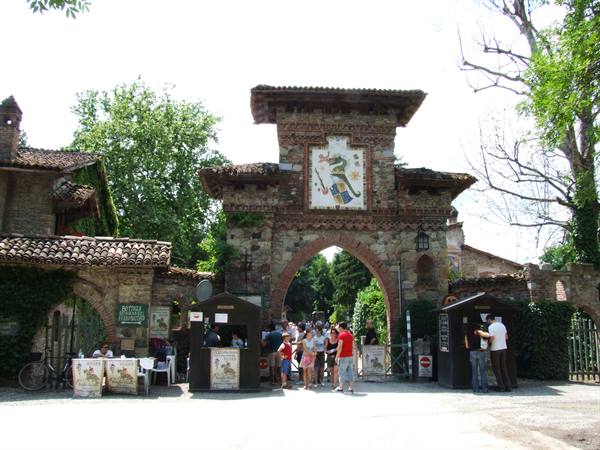 Visitors entering Grazzano Visconti, brick gateway with mosaic coat of arms
