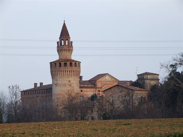 Rivalta Castle: brick machicolated tower rising above winter fields