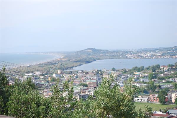coastal town with lagoon, houses among trees and hazy beach in daylight
