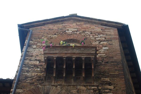 Medieval stone and brick balcony with flowers, diffused light