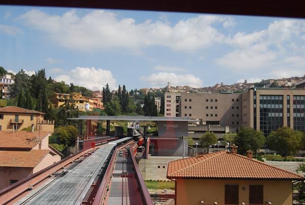 Perugia MiniMetrò track descending among red-roofed buildings and hills
