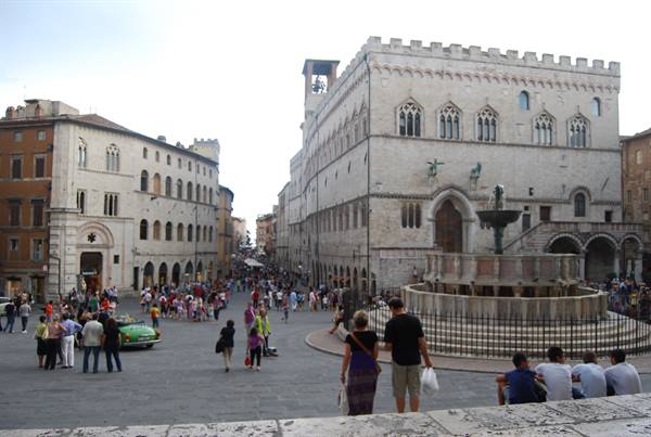 Tourists in Perugia's square beside the Fontana Maggiore and Palazzo dei Priori