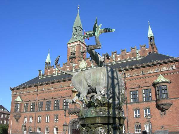 Dragon fountain and tower of Copenhagen City Hall under blue sky