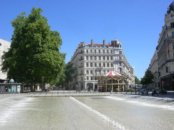 Water jets and red carousel on Place de la République, Lyon