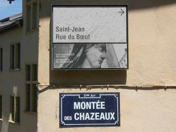 Tourist sign and blue street plaque of Montée des Chazeaux on Lyon wall