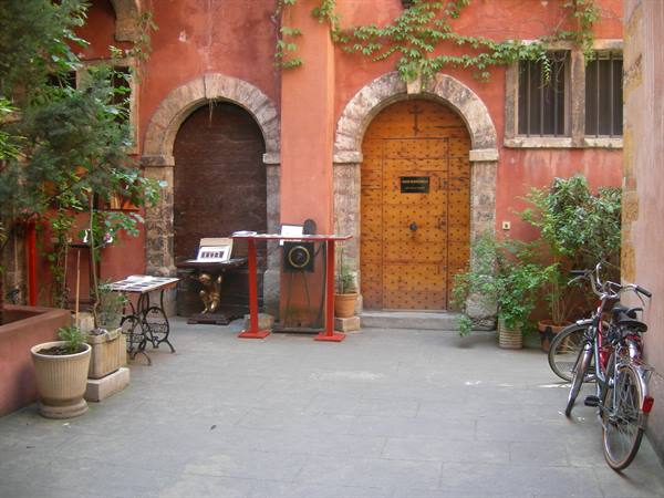 Courtyard with arched wooden doors, stone frames and parked bicycles