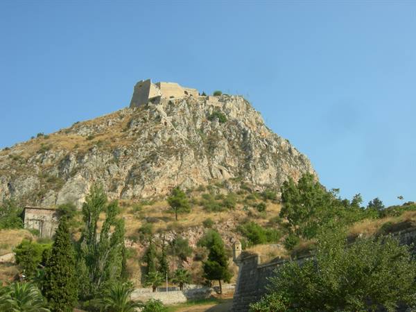 Palamidi fortress atop the rocky hill above Nafplio, trees and stone walls below