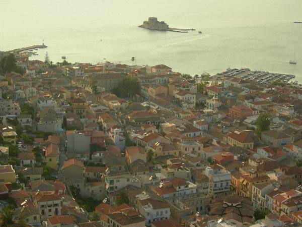 Nafplio rooftops with Bourtzi fortress on the water, golden light