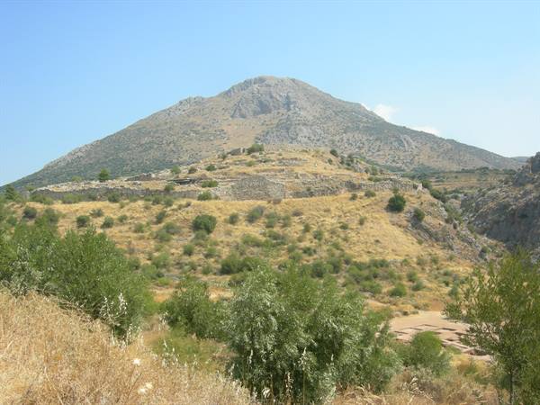 Ancient dry stone walls on grassy hills of Mycenae, blue sky