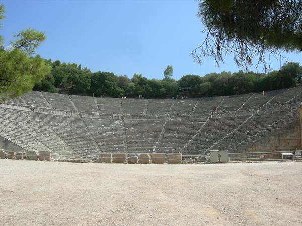 Ancient theater of Epidaurus, semicircular stone tiers under a blue sky