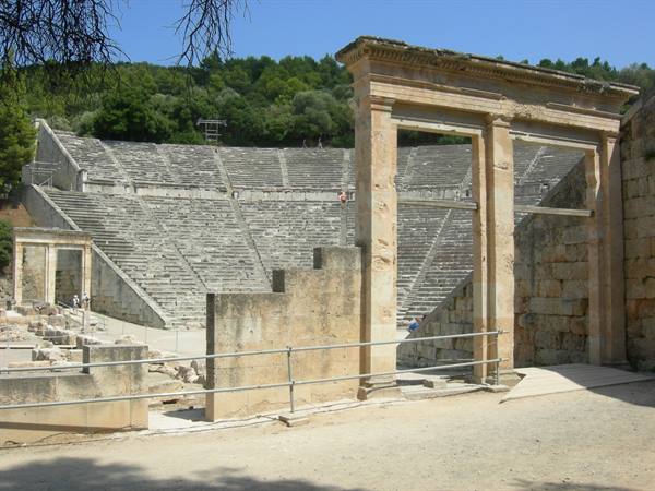 Stone gateway in front of the tiered seats of the ancient theater of Epidaurus