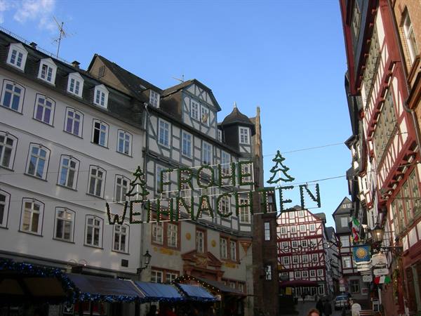 'Frohe Weihnachten' lights strung between half-timbered houses in Bernkastel-Kues