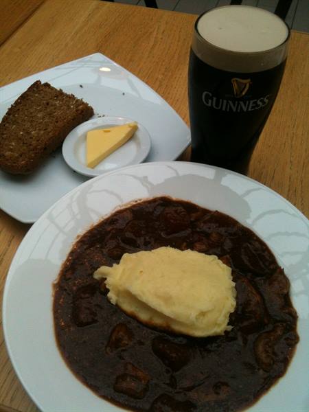 Beef stew with mashed potatoes, soda bread, butter and a Guinness pint