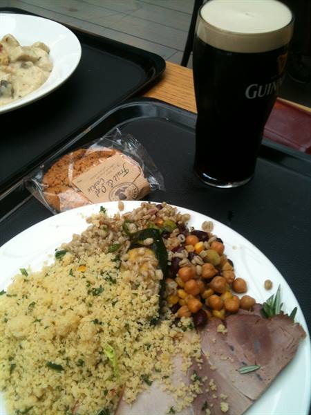 Tray with couscous, chickpeas and roast beef next to a Guinness pint